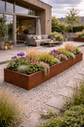 Højbed i cortenstål med farverige blomster ved moderne terrasse